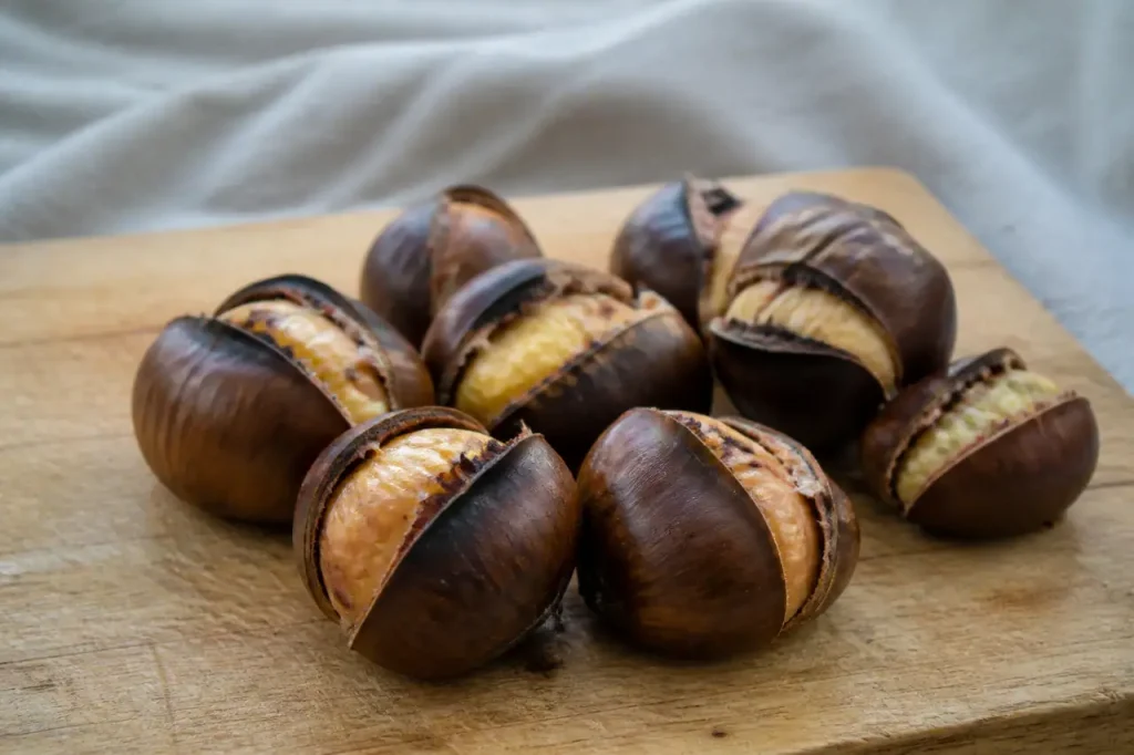 Chataignes cuites fendues sur planche en bois