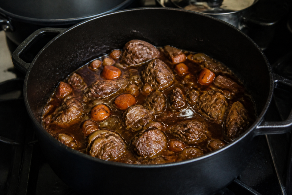 Cocotte en fonte remplie de viande et sauce
