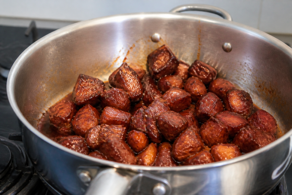 Cubes de porc laques dans une sauteuse brillante