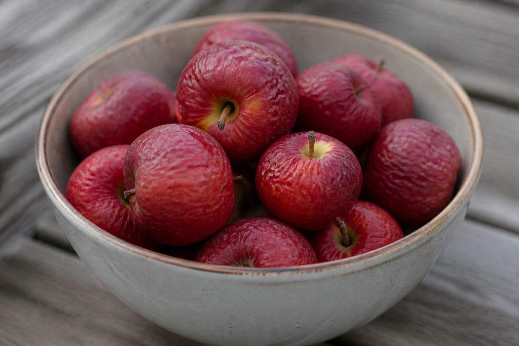 Petites pommes rouges et ridees dans un bol